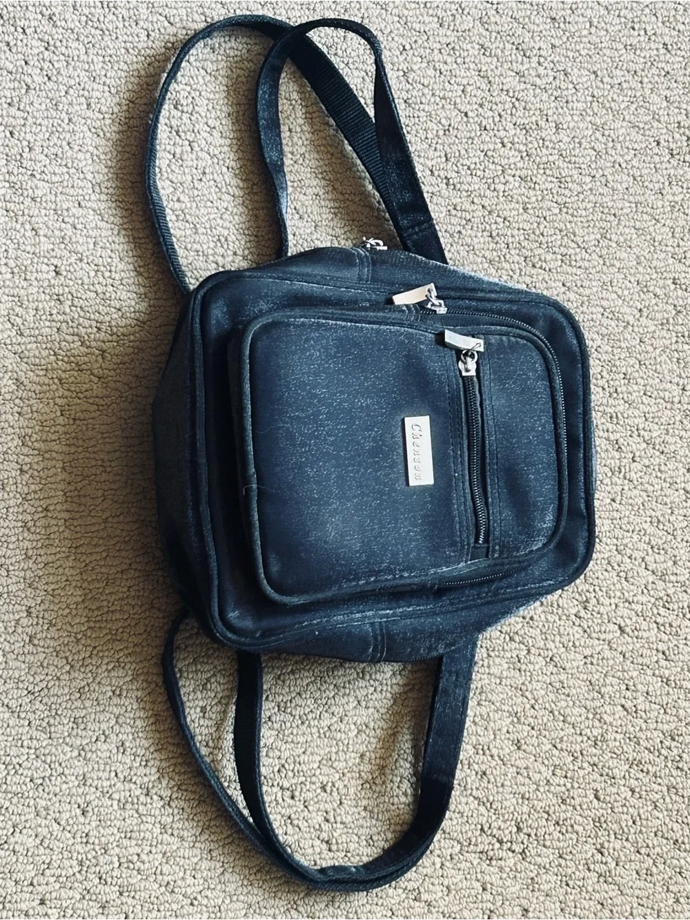 Backpack mini style. Black little purse with lots of compartments and zippers.